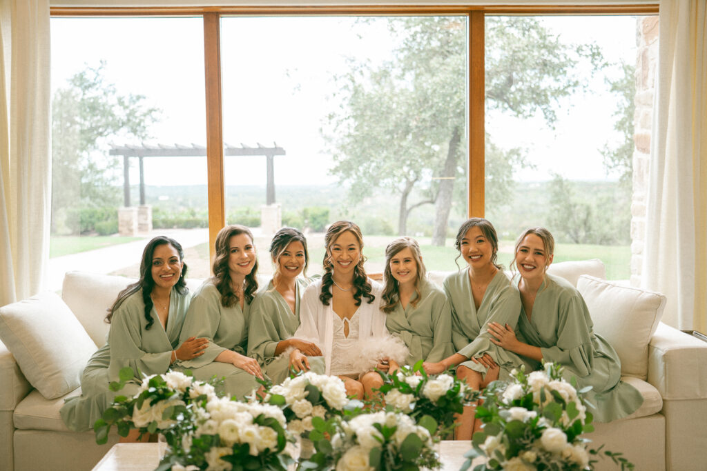 bridesmaids sitting on a couch together at a hill country wedding